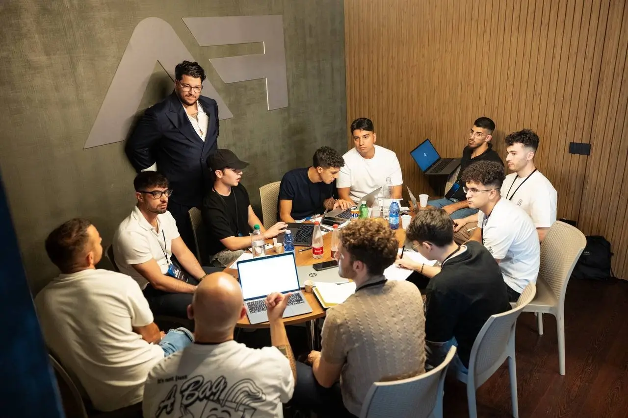 Sala piena di membri al lavoro sui laptop